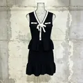 Elegante conjunto de punto de dos piezas en negro con ribete blanco y flor de camelia. - S / Top Y Pantalón / Negro