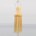 Detailed view of a yellow strapless maxi dress featuring a ruffled waist and pleated skirt. - S / Dresses / Yellow