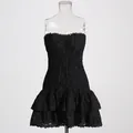 Detailed view of black strapless smocked mini dress with tiered ruffled eyelet hem - Black