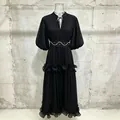 Detailed view of an elegant black French style dress with puff sleeves and ruffles - S / Black