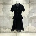 Detailed view of a black knit dress with ruffle waist and lace hem embroidery. - S / Black