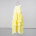 Detail shot of yellow layered cake dress with delicate white lace trim and straps. - S / Bottoms / Yellow