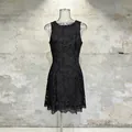 Detail view of an elegant black sleeveless mini dress featuring heavy floral lace embroidery. - S / Black
