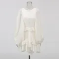 Detailed view of the layered ruffled hem and lantern sleeves on a white court style dress. - S / Top And Bottom / Apricot