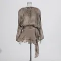 Detailed macro view of pleated fabric and ruffled hemline on a champagne mini dress - Chestnut