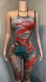 Detailed view of women's halter neck jumpsuit with vibrant Oriental print and green bag. - S / Top And Bottom / Cloud Carp Print