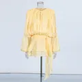 Elegant shimmery light yellow long sleeve blouse with tie waist and ruffle hem details. - Yellow