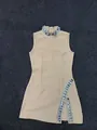 Vista dettagliata dello scollo con strass e dello spacco laterale sul vestito bandage beige - Taglia S / Albicocca