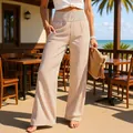Detailed view of high-waisted vertical striped wide-leg trousers in a summer resort setting - S / Bottoms / Apricot Stripe
