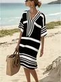 Femme élégante portant une robe à rayures noires et blanches sur une plage ensoleillée - Noir
