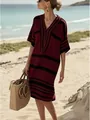 Mannequin posant sur une plage ensoleillée en robe tunique à rayures bordeaux et col en V - Rouge