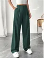 Detailed view of elegant dark green high-waisted straight-leg suit trousers for women. - Green