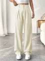 Close-up detail of elegant high-waisted straight-leg suit trousers in cream white - Ivory