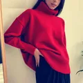 Close-up detail of a soft red oversized turtleneck knitted sweater with ribbed texture - Red