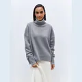 Close-up of a soft grey turtleneck sweater featuring a comfortable oversized knit design - Gray