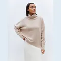 Close-up of women's soft beige high turtleneck knit pullover with ribbed edges - Khaki