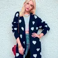 Close-up view of women's oversized knit cardigan featuring light blue heart patterns. - Dark Blue