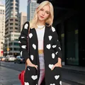 Black oversized knit cardigan for women featuring white heart patterns and large pockets - S / Tops / Black