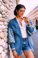 Streetstyle-weergave van een blauw opengewerkt gebreid vest met gestreepte mouwen - S / Tops / Teal