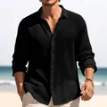 Detail view of men's black textured long-sleeved casual button-down shirt at beach. - S / Tops / Black