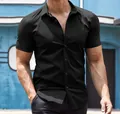 Gros plan d'un homme musclé portant une chemise noire ajustée à manches courtes. - S / Hauts / Noir