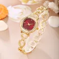 Detailed close-up view of an elegant gold women's bracelet watch with red dial and rhinestones - Watch Only / Red