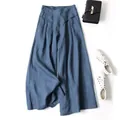 Styled flat lay of blue cotton-linen wide-leg cropped pants with high waist detail. - Navy Blue