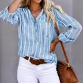Detail shot of a women's blue and white striped button-up shirt with V-neckline - S / Tops / Blue