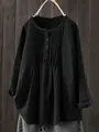 Close-up of black linen cotton shirt featuring elegant chest pleats and button neckline detail - Black