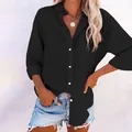 Detail view of a black women's long-sleeved button-down shirt with a front pocket - S / Tops / Black