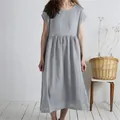 Detail view of a loose grey cotton linen dress with a round neck and short sleeves. - Light Gray