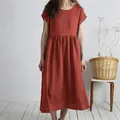 A detailed view of this loose terracotta linen midi dress featuring a pleated waist. - Rust Red