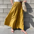 Casual high-waisted yellow linen wide-leg pants for women in summer outdoor setting - One Size / Bottoms / Yellow