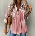 Close-up of pink women's shirt featuring elegant white cherry blossom floral print - Pink