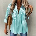 Dettaglio di una camicia a fiori azzurra da donna a maniche lunghe indossata da una modella - Taglia S / Top / Verde