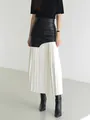 Detailed view of elegant black and white pleated patchwork midi skirt on model - S / Bottoms / Black and White