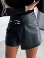 Detail view of black PU leather skort with metallic U-buckle and wrap front design. - S / Bottoms / Black