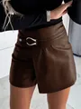 Detail of high-waist brown PU leather skort featuring a stylish silver metal buckle. - S / Bottoms / Tan
