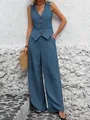 Model posing in blue linen vest and trousers set against a white textured wall backdrop - S / Top And Bottom / Blue