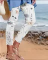 Detailed view of floral capri pants with hollow lace trim at the leg opening. - S / Bottoms / Rainbow