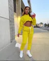 Model trägt lebhaften gelben Cropped-Hoodie und passende Jogginghose im Freien - M / Oberteil Und Unterteil / Gelb