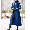 Full-length view of an elegant women's long blue leather trench coat in a city street setting - S / Tops / Blue