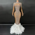 Vista detallada de vestido de noche de malla con pedrería y dobladillo de plumas blancas - Albaricoque