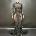 Vista detallada del vestido de noche de malla negra con brillantes pedrería y plumas. - Negro