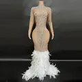 Vista detallada del vestido de noche de malla nude con pedrería y plumas blancas. - Caqui