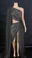 Detailed view of a black one-shoulder sequin evening dress with a high side slit. - Black