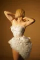 Detailed view of elegant white feathered strapless mini dress with ruffled skirt - XS / White