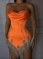 Detail view of orange strapless corset dress with heavy rhinestone and gold fringe trim - Orange Red