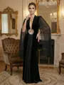 Elegant black evening gown with V-neck and sheer mesh sleeves in a classic luxury interior. - S / Black