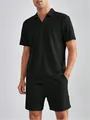 Primo piano di un set polo a coste nero da uomo che mostra il tessuto strutturato e la vestibilità - Taglia S / Top E Pantaloni / Nero